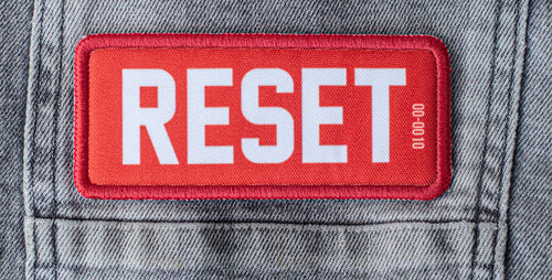 RESET Founding Patch on denim jacket — 
NFC embedded, numbered, non-fungible. One of 1,000.